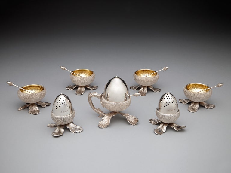  A rare set of silver condiment holders by Alexander Crichton, naturalistically fashioned into the form of acorns, including 4 salts as cupules with gilt interiors and spoons, each with an acorn finial, 2 pepper pots with removal nut and a mustard