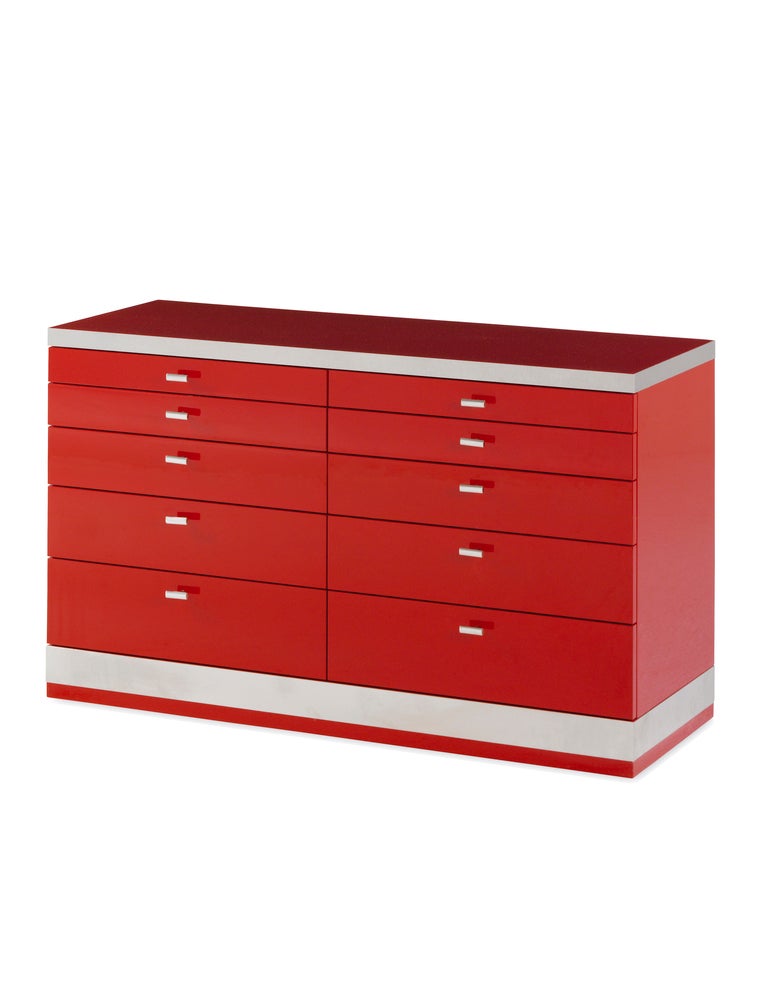 A pair of red lacquer and satin stainless steel commodes by Willy Rizzo, each with ten graduated drawers.

Signed by Willy Rizzo.
