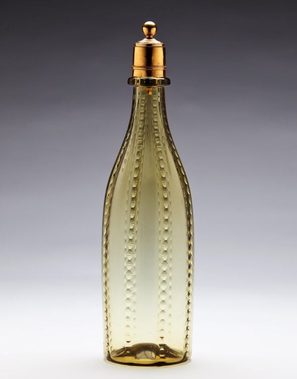 An early 19th century glass bottle with a gilt stopper.