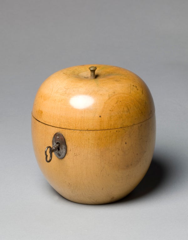 A fruit wood tea caddy in the form of an apple, stained on the top with green lines. Retaining much of the original lead lining.