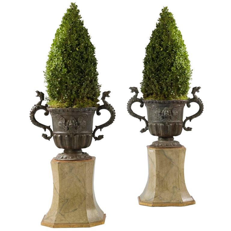 A Pair Of Lead Urns With Scroll Handles On Cushion Moulded Bases