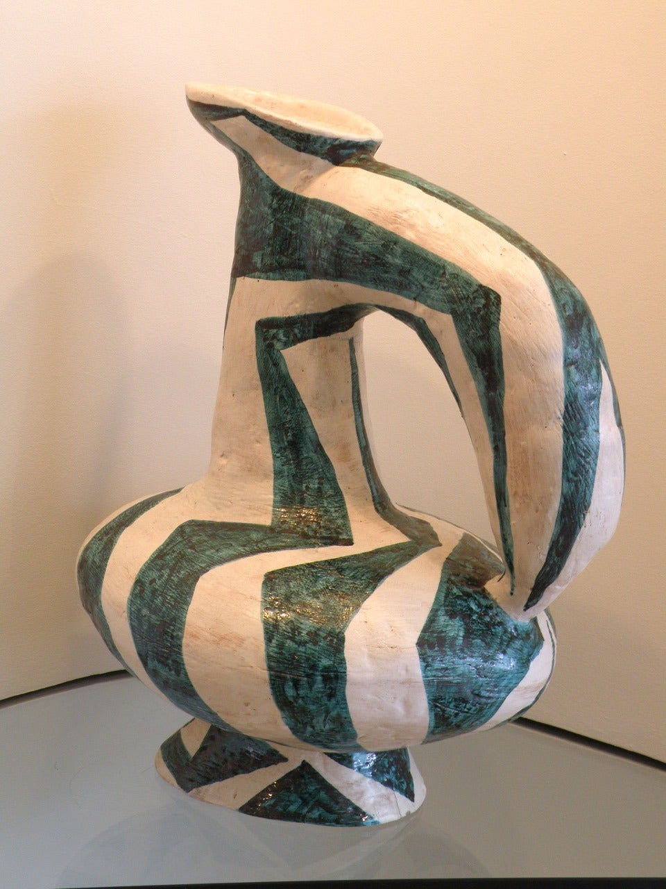 In the form of a muscular pitcher, decorated with a bold abstract design in green (copper oxide) glaze on white slip ground, over red earthenware body,
signed Meli