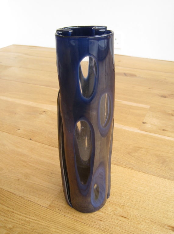 Zylindrischer Korpus aus klarem Glas, ummantelt von tief indigoblauem Glas, mit geschliffenem Dekor.
Signiert 'Venini Italia'.