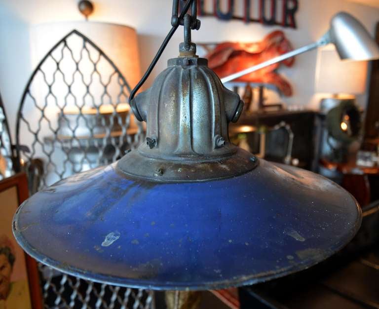 Vintage industrial/workroom pendant fixture with a rich, royal blue enameled reflector mounted to a cast iron housing shaped rather like the top of a fire hydrant.  We restored this completely with a new socket and with that great cloth-covered cord