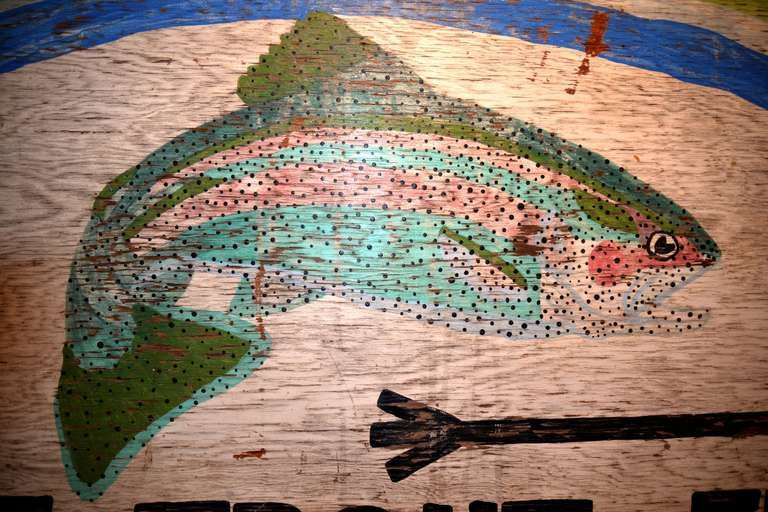 Twentieth century roadside goodness, right here.   A colorful, whimsical  make-do sign for the Rainbow Springs fishing area, Somewhere, USA.   No license, no limit.  No reason to give a damn about a game warden.  

Get  it for the fisherman in