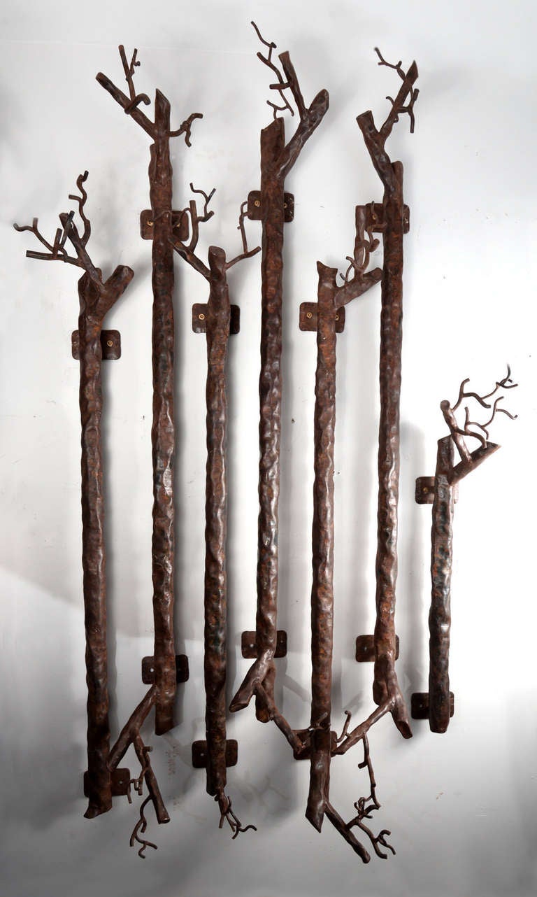 These old hammered steam pipes have been refashioned into seven individual pieces, each with mounting plates and leafless branchlike clusters at the ends,  suggesting they were installed with a significant weight capacity in mind.  In what capacity,