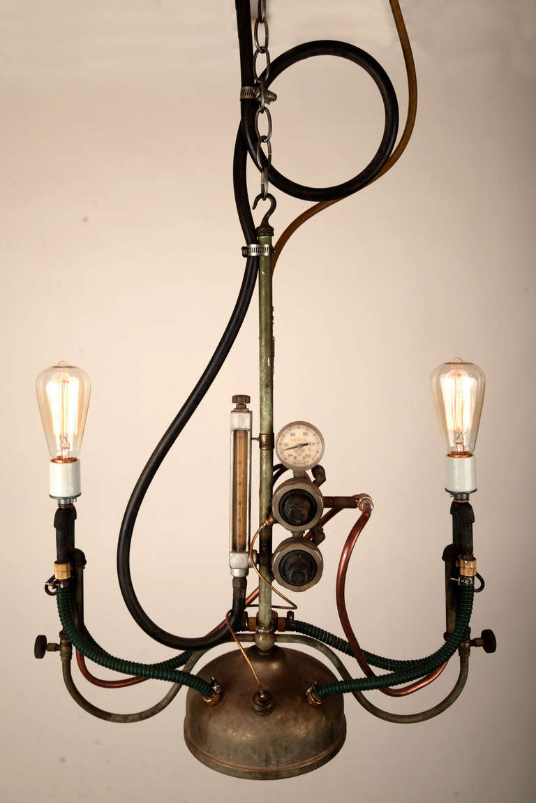 It's as if Tim Burton, H.R. Giger and Sanford & Son got together and made a pendant light fixture.  You can see the hoses, copper tubing, chain, the nickel-plated vessel, the gauges and dials and such.  We've lamped it with a pair of Edison-style