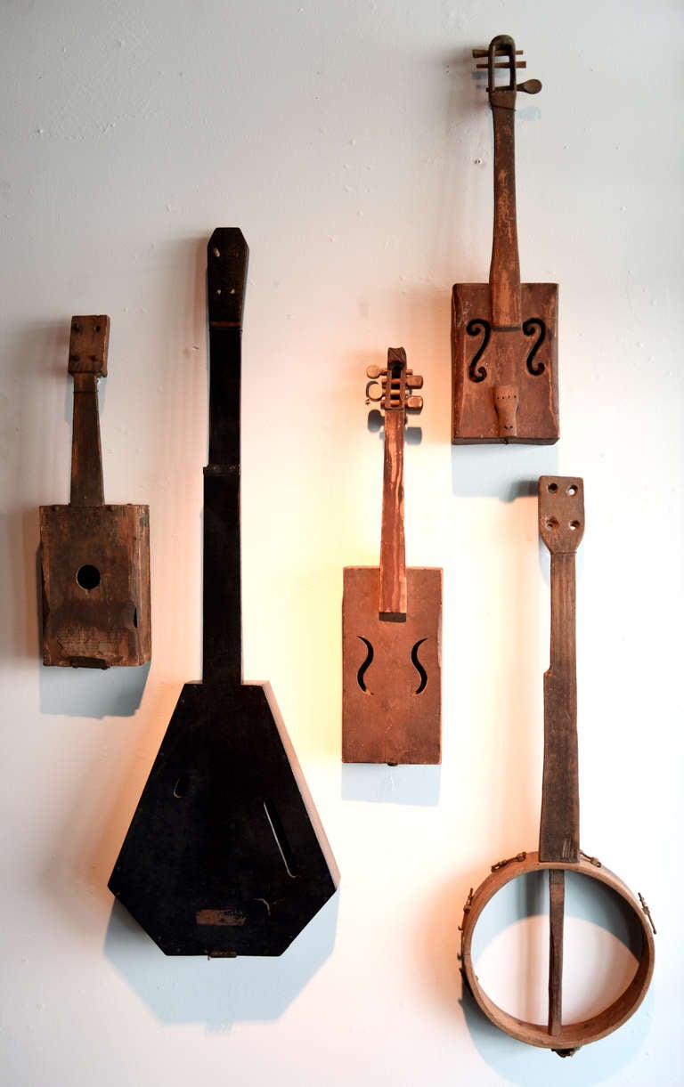 Primitive, hand-carved stringed instruments in classic shapes.  Crude and incomplete yet familiar.  A wonderful set for the music lover.