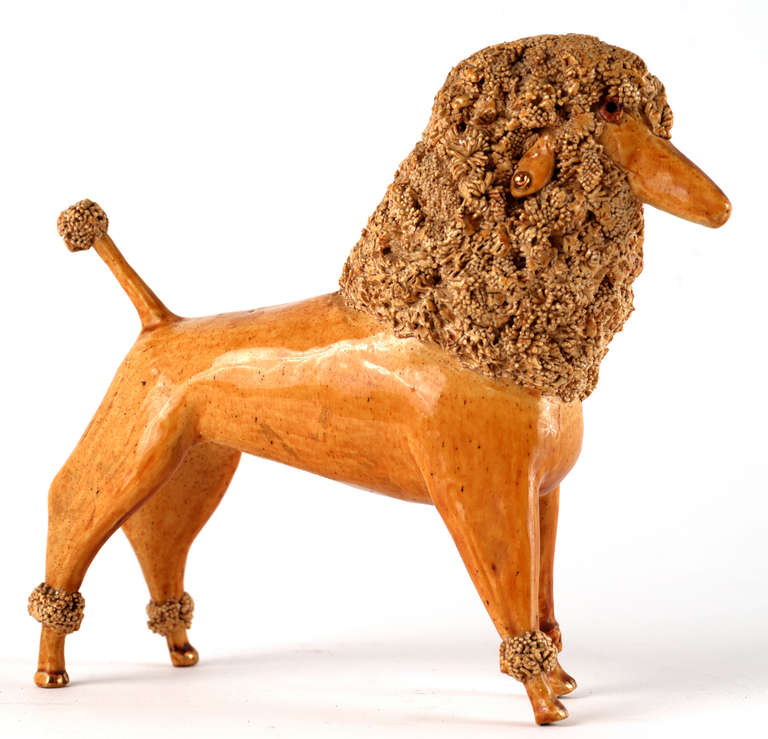 Sweet, slightly cartoonish form and a lovely glaze, this miniature sculpture of a  fancy groomed poodle with a yellow coat and gold stud earrings  is signed 'To Joe from Dot 8-22-55' underneath.