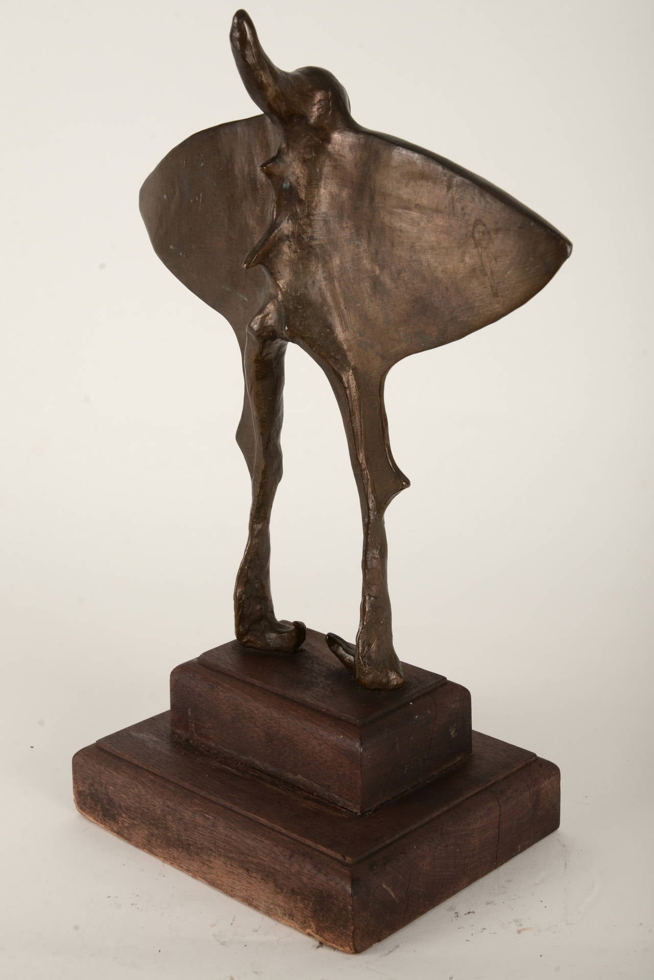 Bronze casting mounted on a two-tiered wooden base. The faceless figure is a stylized female form suggesting wings, exaggerated spine and inward turned feet. This is a pretty awesome piece but it's not suggested as a mother's day gift.