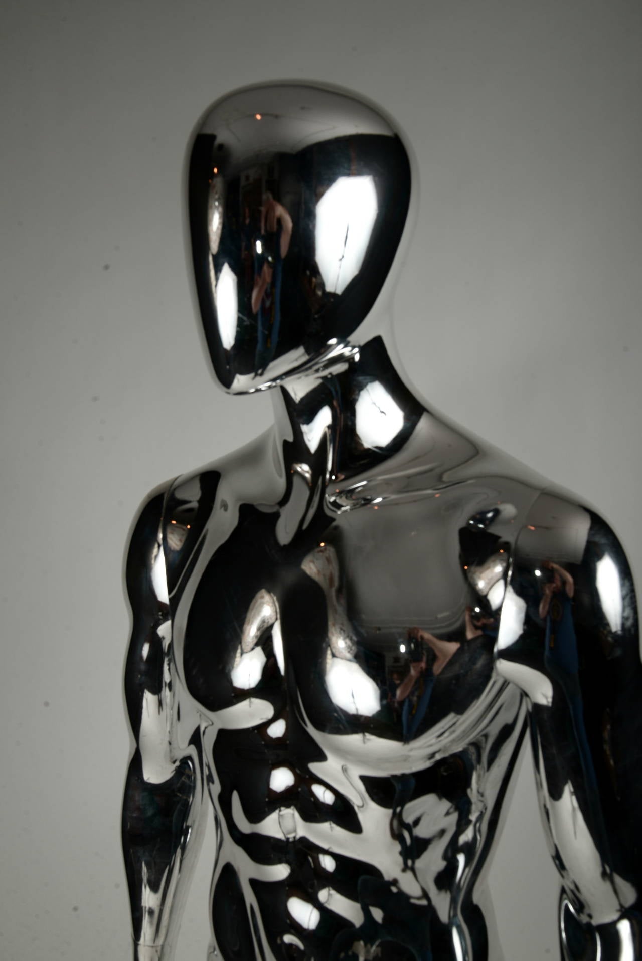 Four-piece lifesize faceless silver colored mannequin with round glass base.