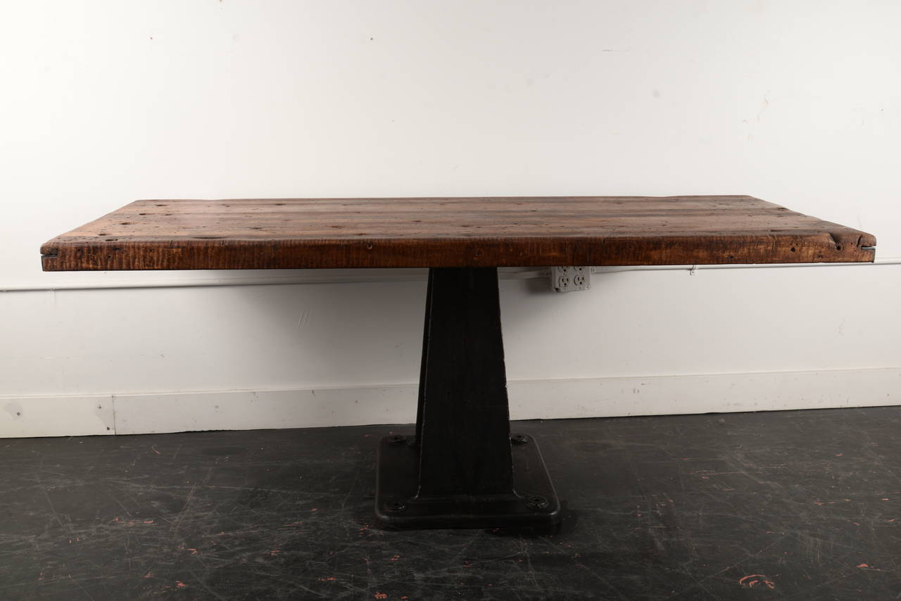 This table is a union of two beautiful vintage elements. The top is a maple school house shop class surface and the base is a vintage cast iron Industrial stand. These have been professionally attached for solid adhesion and great stability.