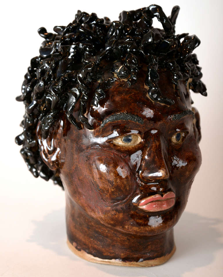 A life-size glazed ceramic sculpture of  African-American woman's head, styled  with twisted curls and red lipstick.  Beautiful.  So naive, perhaps a student piece.