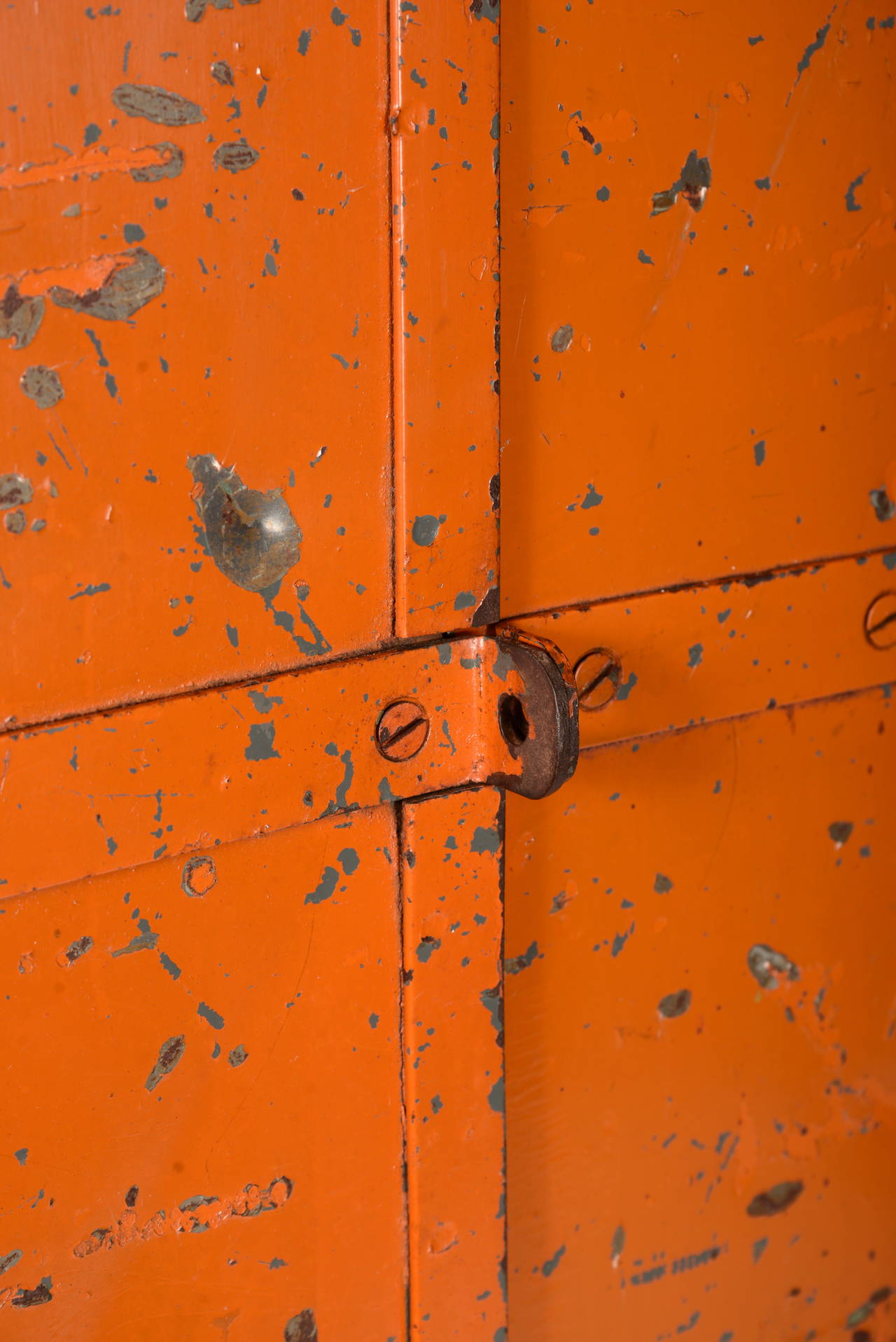 Pumpkin colored folk art steel tool cabinet on pipe legs.