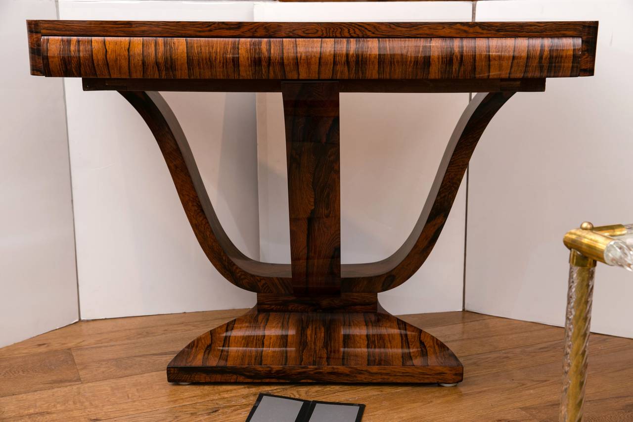 Pair of elegant French Art Deco console tables in bookmatched Brazilian rosewood veneer on oak, shown with a shallow drawer and a very unique tulip shaped base, circa 1930. Incredible quality of wood.
(Just refurbished and polished).