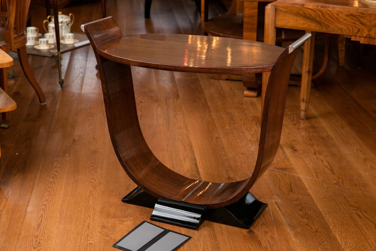 Unique French art moderne mahogany tray table or side table with elegant tulip shaped base on black lacquered bracket feet, embellished with silvered metal to the base and top arms, France, circa 1940.
Height to tabletop is 25