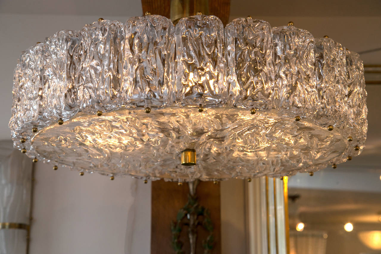 This shimmery fixture blown to appear as if constructed from blocks of ice is comprised of 25 separate glass pieces and are electrified for up to 5 sockets (each socket 40 watts).
Overall measurement of glass 28” diameter, 7” high.
Available as a