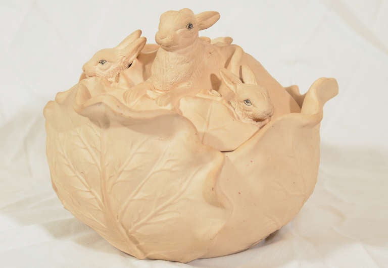 A molded continental Caneware game pie dish in the form of a cabbage with four rabbits peeking out from the cover. 
Caneware is an unglazed stoneware. In the 1780's Wedgwood created the first Caneware game pie dishes with ornamental covers. Like