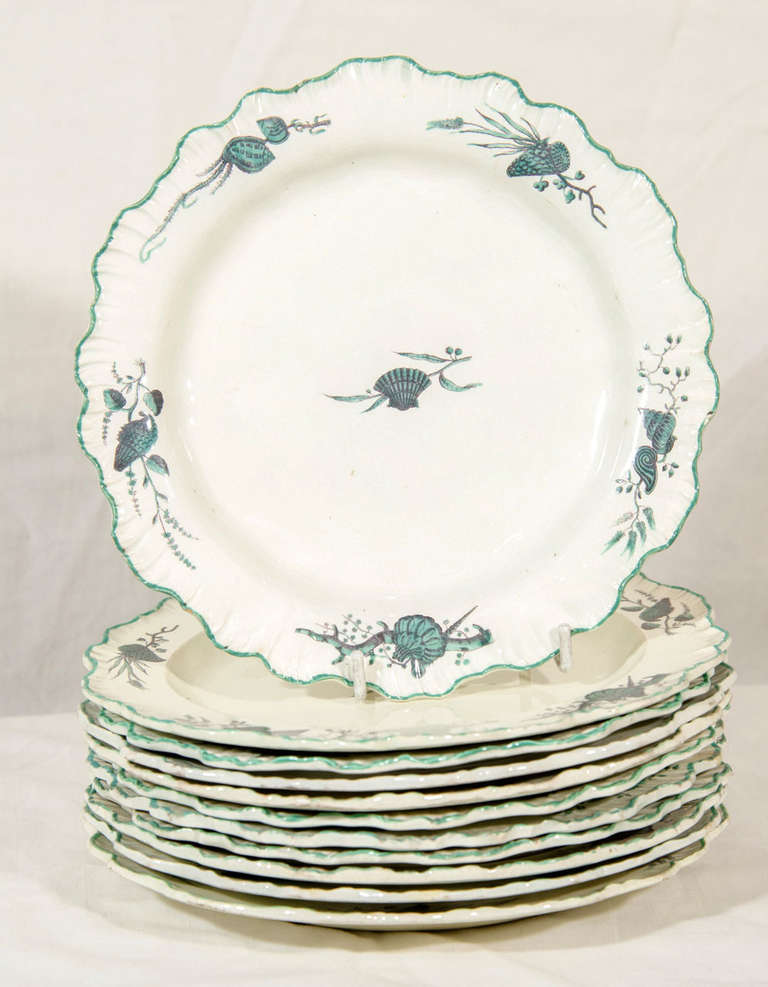 A set of twelve Wedgwood creamware shell edge dishes. Each center is painted with a single clam shell. The borders are painted with a variety of sea shells. Shell edge bordering made its first appearance at Wedgwood during the 1770s. 