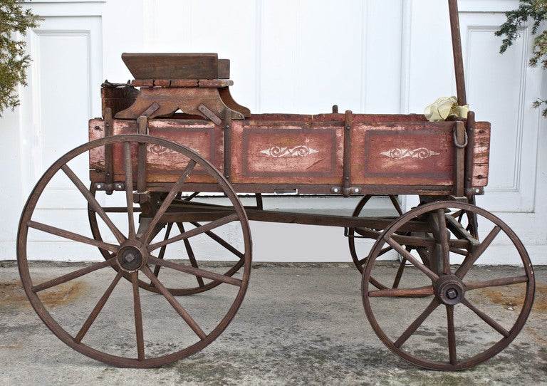 A rare and early diminutive goat wagon or cart; in its original paint with contrasting stencil decoration.  Essentially a slatted diminutive 'buckboard' with removable sides and seat; intended for developing 'driving' skills during childhood.  This