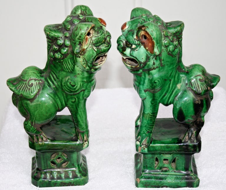 A pair of Guangxu period (1875-1908) ceramic incensors of vibrant coloration and particularly eccentric appearance.  Reticulated pedestal bases.  Each figurine head has an original insertion hole for metal incense burning vessel or candlestick cup. 