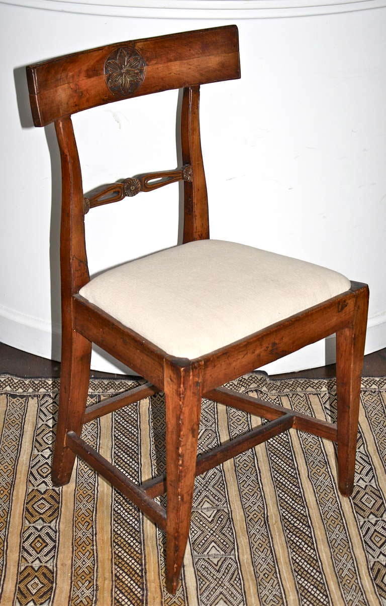 A Piedmontese origin fruitwood side chair with meticulous foliate carved crest rail patera and ribbon.  Slip seated with h- and back stretchered tapering square legs;  slightly raking at the back.
Another single Piedmontese fruitwood side chair is