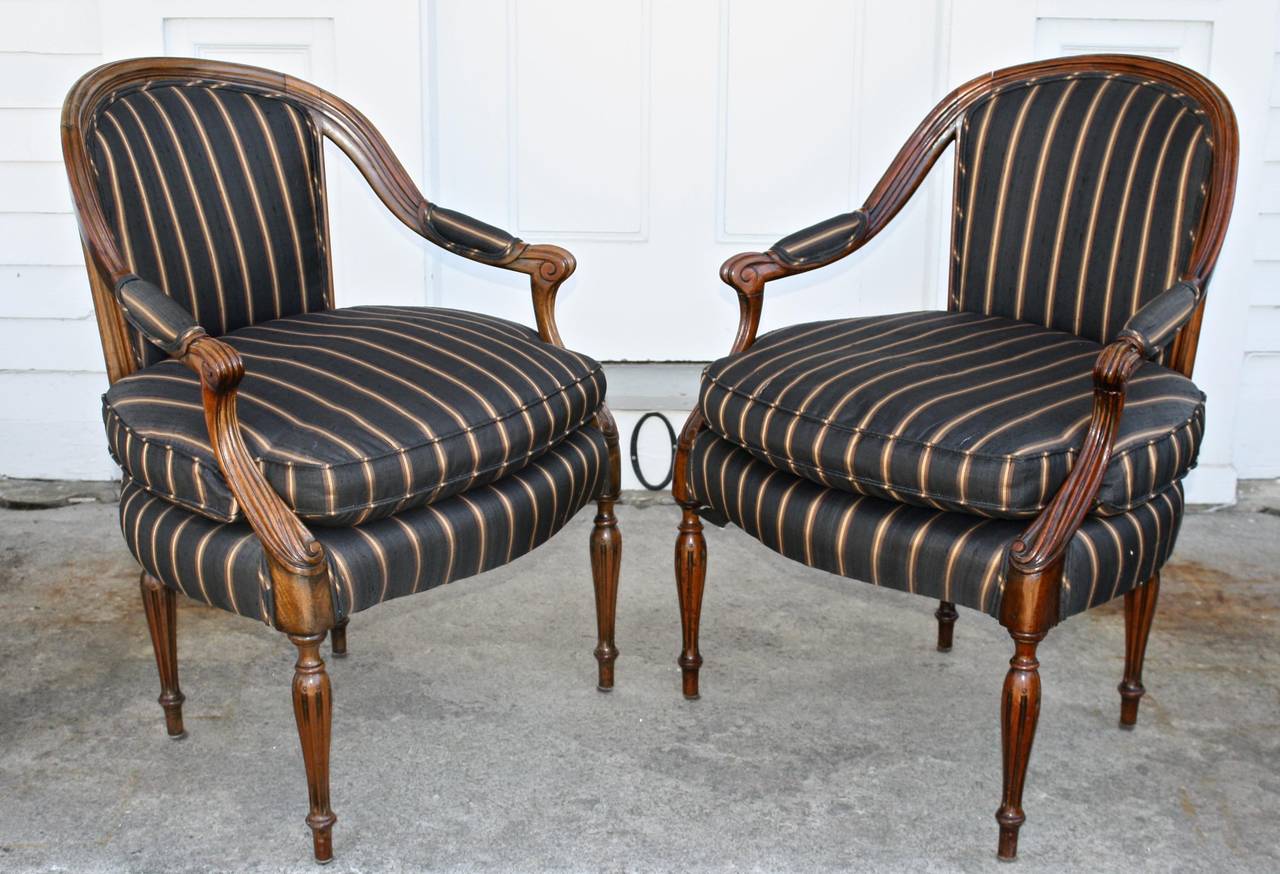 English-made armchairs in the French 'en cabriolet' bergere manner, except that these two were deliberately left 'open arm'; never upholstered at their sides. Designed for comfort, the arms flow downward from the back of their coved chair frames. 