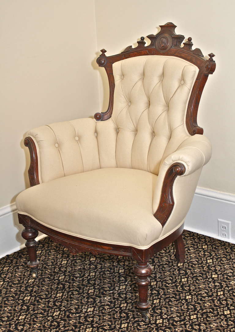 An American Rococo Revival bergere or armchair; framed in walnut and burl, button tufted and channel upholstered, with Jelliff's signature silhouette bust centered on its crest rail.  Upholstered armchairs of this period were oft made with just