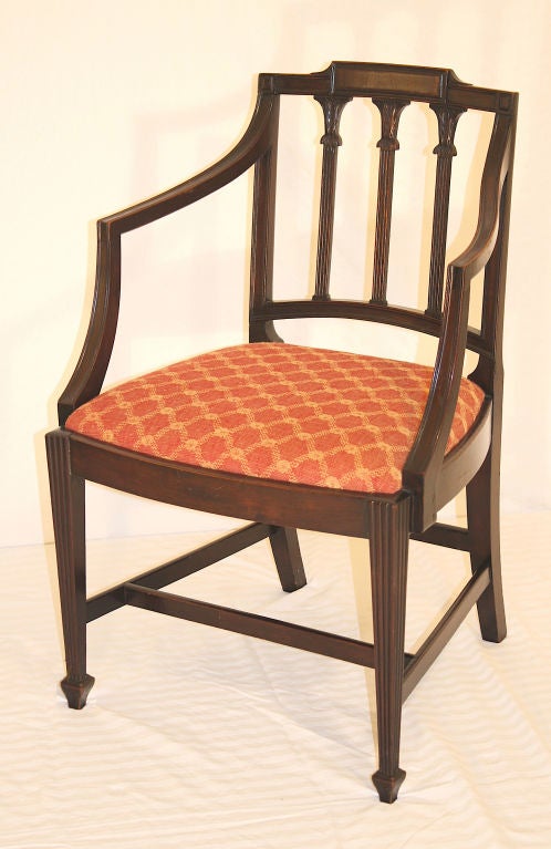 A matched, fully period set (2 armchairs and 8 side chairs) in hand-carved dense mahogany, bow front slip seated, reeded back stiles with foliate capitals, and tapering front legs with reeded facings; on spade front feet.  From the shop of Abraham