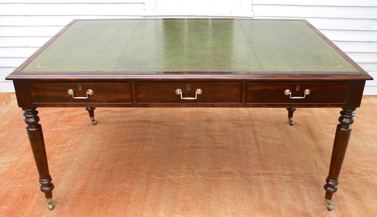 An antique William IV revival leather-topped library table or center table; with three frieze drawers on each side.  It may also be used as a partners 'bureau plat', writing table, or small conference table;  with chairs of appropriate height.  The