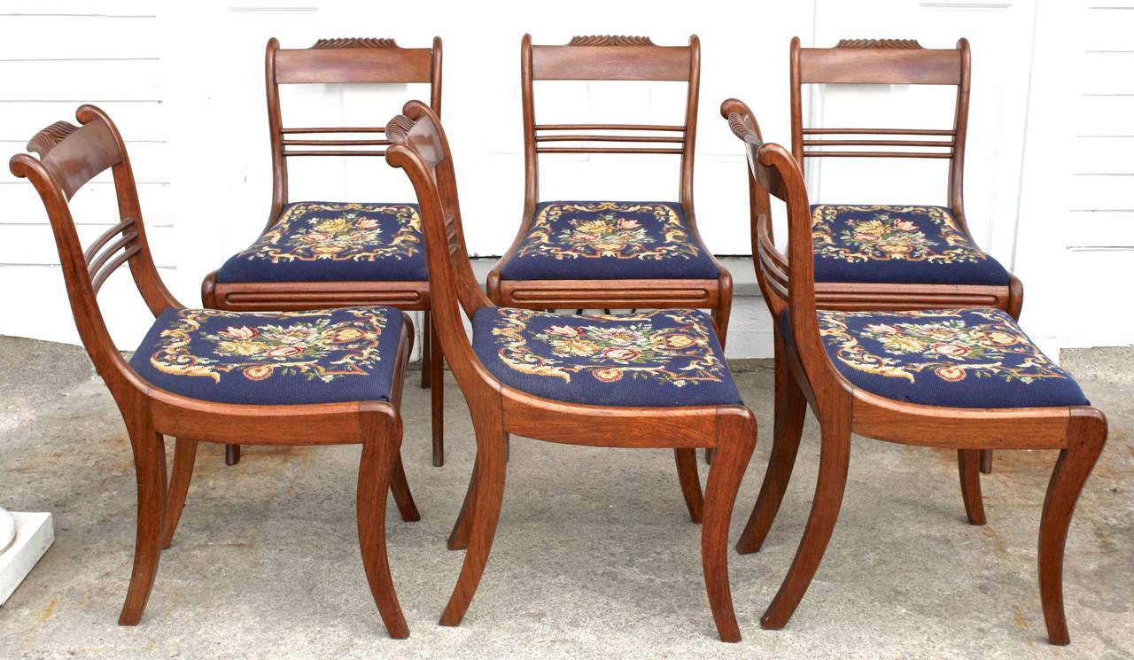 Six gadroon crested padauk Klismos sabre-legged dining chairs, with hand-stitched needlepoint slip seats in mint condition. Attributed to Antoine Gabriel Quervelle, French trained Philadelphian furniture maker. Six of a very large set of side