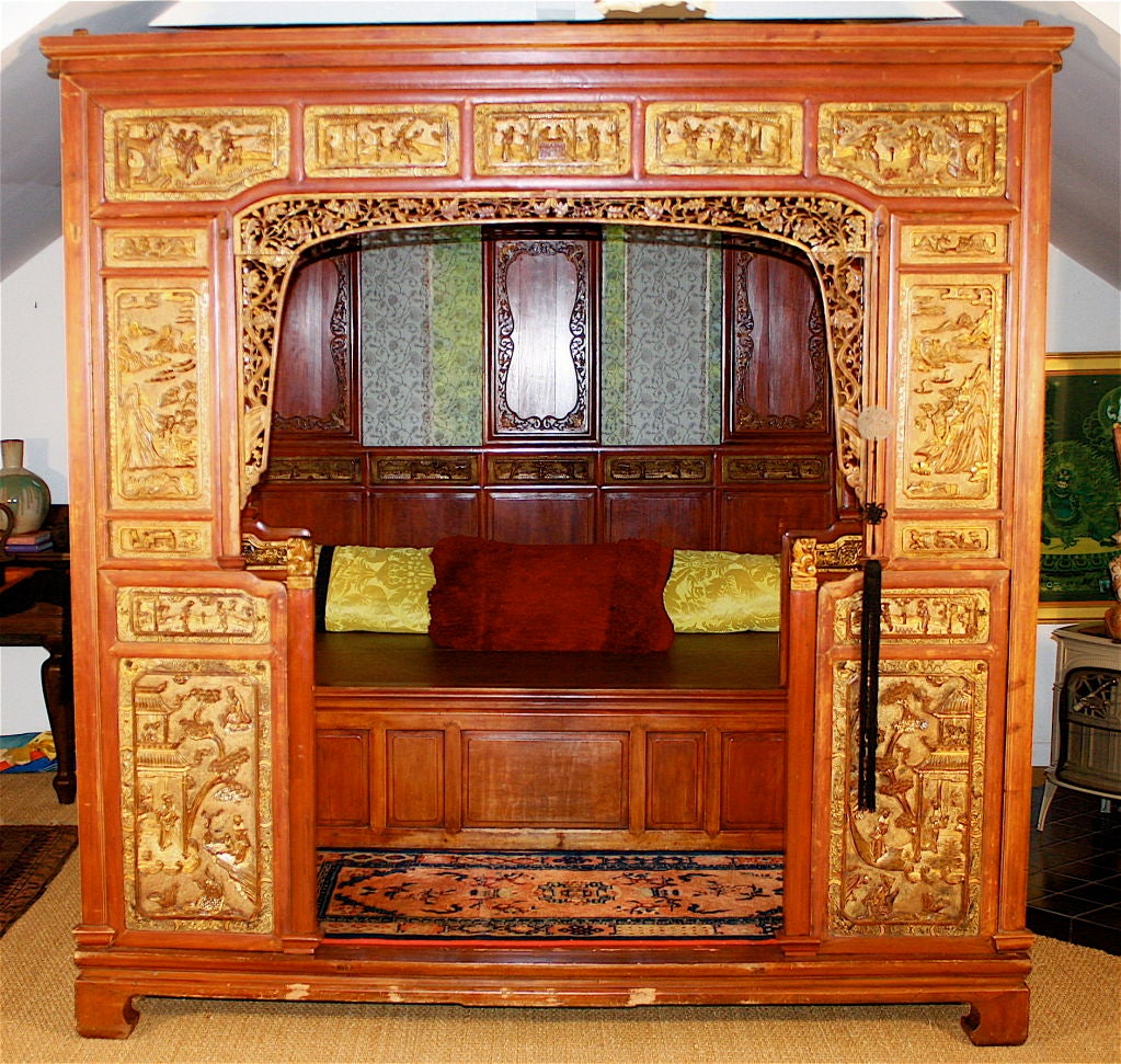 A Qing Dynasty monumental intricate 'opium' bed;  also referred to as a wedding bed or Lo-han.  An ample vestibule or foyer substantially increases the overall size.  The gilded intaglio panels are presumably allegorical; further embellished with