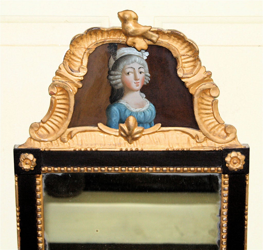A carved gilt-gesso trimmed, ebonised frame 'looking glass' mirror; with a reverse-painted 'eglomise' of a fashionable lady as a crest panel inset.
Literature:  THE MAGAZINE ANTIQUES (June 1966), 
