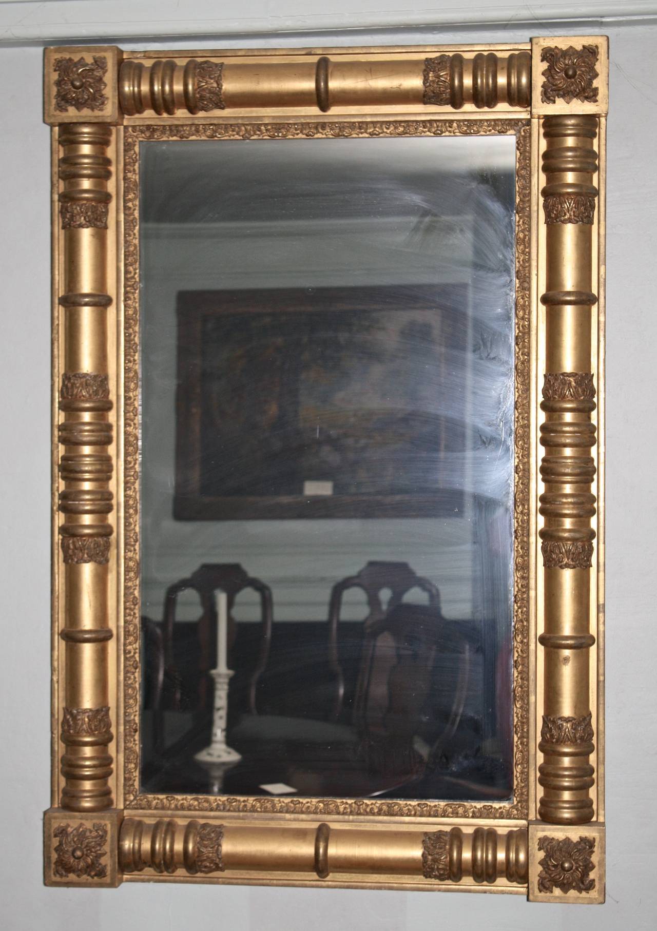 A massive giltwood pier mirror with its original gold leaf surface applied on very complex turnings and carvings.  The original mirror plate has been replaced for better  visibility.  Though firmly attributed by familial narrative to the shop of