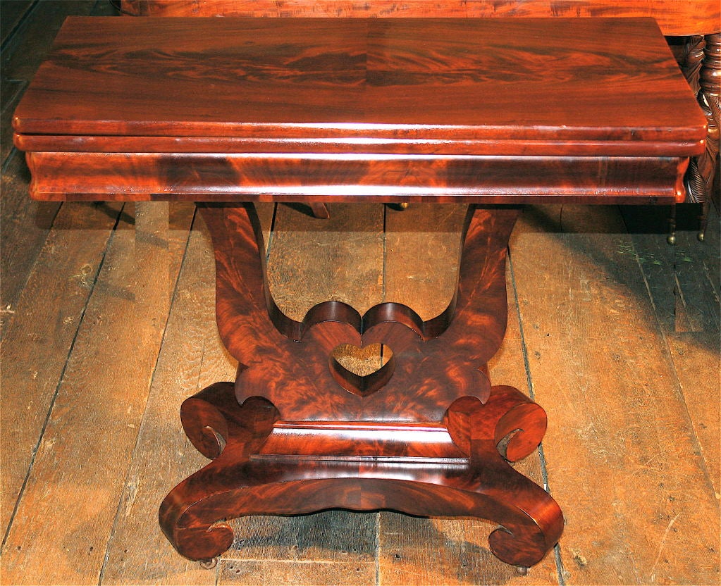 Attributed to the shop of J. & J. W. Meeks of New York, Boston and New Orleans; a specimen Classical or 'Empire' game table of flame mahogany<br />
and crotch mahogany veneers.  The un-strung open lyre form pedestal, <br />
centered with a heart