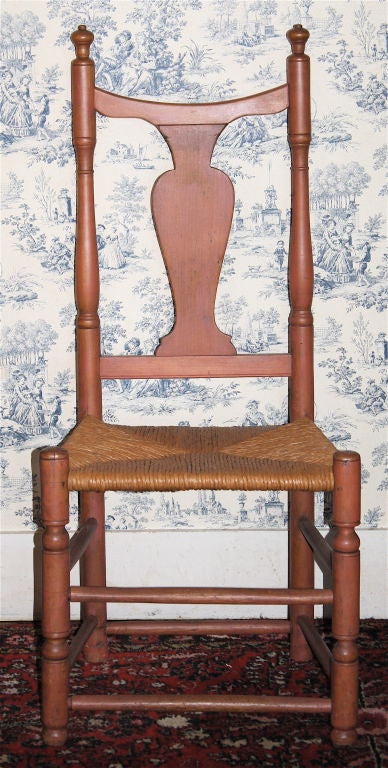 A rush seated vasi-form or baluster splatted side chair, in an unusual
salmon paint-stain; that appears to be possibly original to the piece.
Likely of Massachusetts Coastal origin;  possibly as far south as the islands
off the Cape.  A less