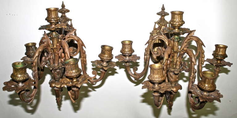A PAIR of Neoclassical-inspired five candle ormolu sconces; the tier of of four candles on each is swing-armed.  This pair is purported to be two of a larger set specified for a Hudson Valley Astor family estate house library by a prominent NYC