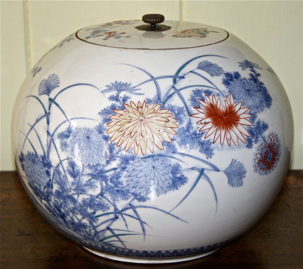 A Japanese porcelain water pot or 'mizusashi', of melon jar 'shonzui' form. Shonzui was a Japanese potter who worked in China in the 16th century. Decoration is of Kakiemon style, with pheasants amid prunus and blossoms; primarily blue and white,