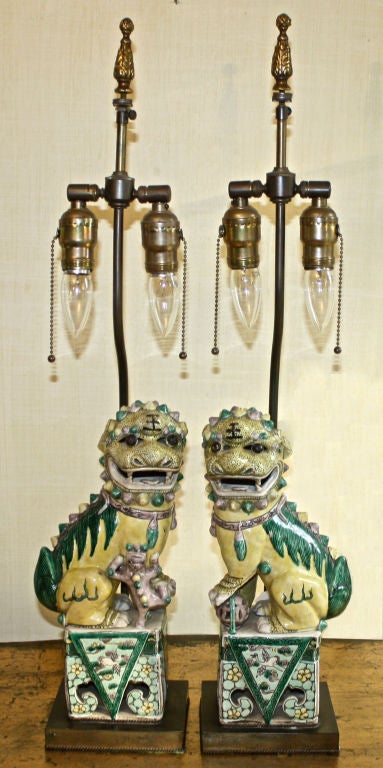 Chinese Famille Verte Fu Lion FACING PAIR, male with sphere and female with cub; mounted as lamps.  Glazed biscuit figures of Buddhist lions of the Kangxi Period 1662-1722.  Desirable coloration and fine decorative detail; reticulated porcelain