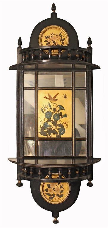 A FACING PAIR of English Aesthetic Movement ebonised and mirrored demilune wall brackets or shelves, with hand painted bird and floral scenes; trimmed with parcel gilt.  Attributed to James Shoolbred & Co.; the painted plaques being characteristic