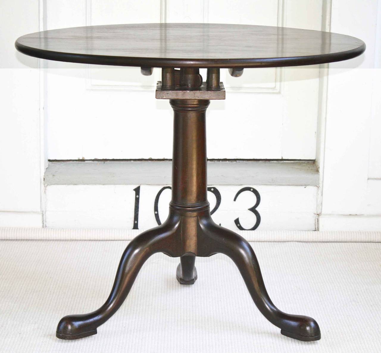 An American Southern Queen Anne snake footed Carolinian walnut tilt-top tea table with 'bird cage', to permit swiveling for graceful service.  A plain-edged single board top with cannon shaft pedestal, its three snake feet have been hollow-carved to