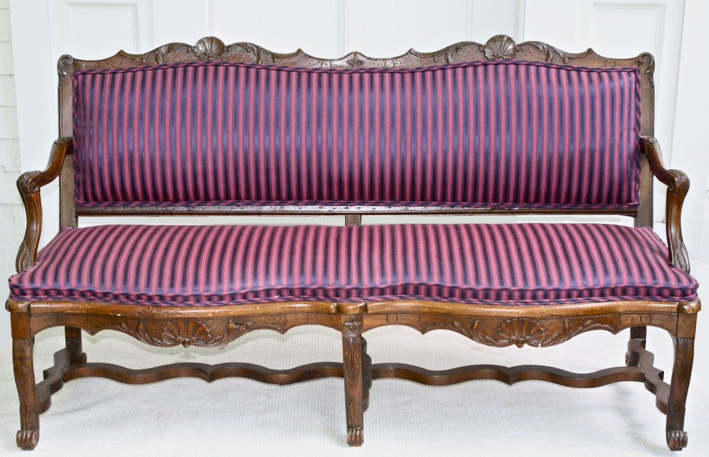 A slightly diminutive carved walnut Austrian canapé or settee, made at the outset of the reign of the Empress Maria Theresa.  Though its dating precedes the Franco-Austrian alliance,  Regence and early Louis XV period French stylistic influences