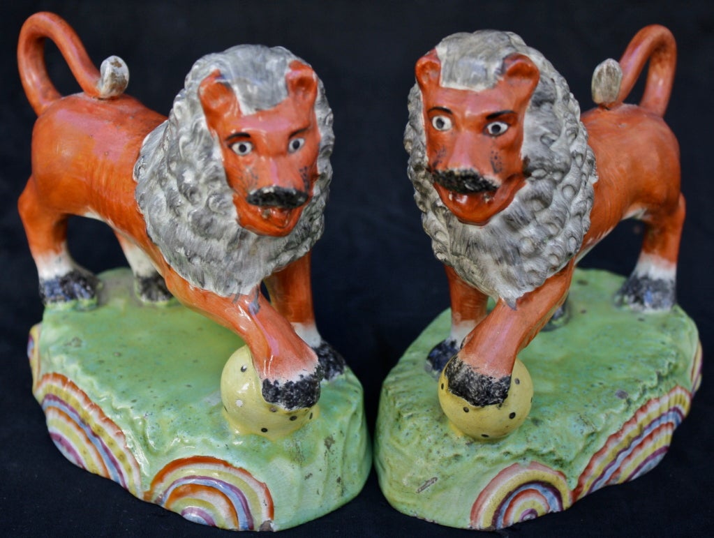 A facing matched pair of pearlware cinnamon bodied lions on grassy plinth bases, faced with three shell-like rainbow colored fans.  Obadiah Sherratt (1775-1846) was a Staffordshire potter in Burslem.  His figurines of lions and other aggressive