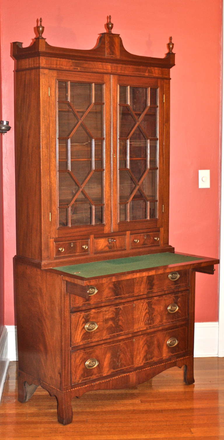 In the Hepplewhite manner, a finely inlaid crotch and flame figured mahogany secretary bookcase of a slightly smaller scale.  Made at Salem in the 1790s,  its three drawer lower case measures 38.5