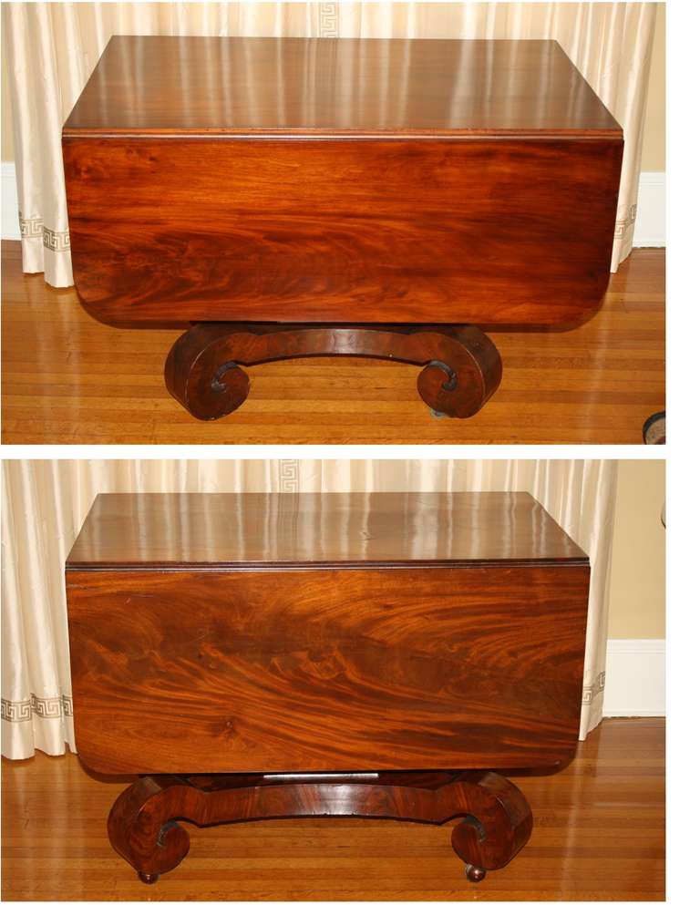 A 'composed' pair of figured mahogany single pedestal drop-leaf tables; the principal difference being a slightly larger scroll foot spread to the base on one of the tables.  Made to serve as formal 'morning room' breakfast tables, or small dining