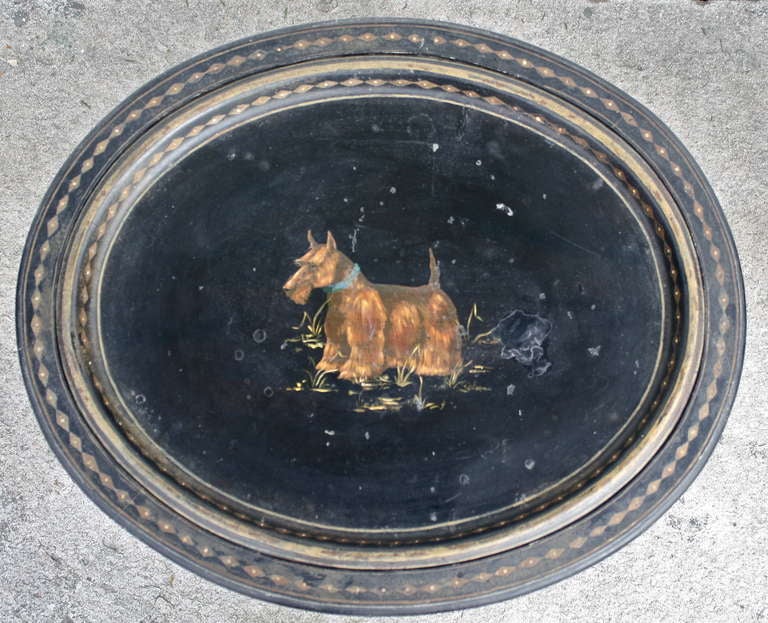 An early 19th century canine portrait of a Wheaten or Lakeland Terrier on an exceptionally fine black lacquered and stenciled oval tole tray.  The tray is inset on a complex 'later' eight legged bamboo-turned and spoon footed stand. The original