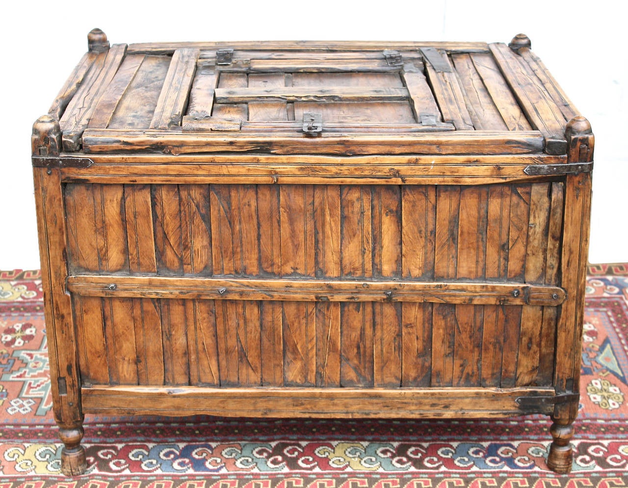 A primitive provincial slatted-elm Suzhou coffer on turned tassel feet, with a lockable hatch door and domed corner tops. It may have been originally intended for a culinary purpose; and/or for contents having some value, as it was