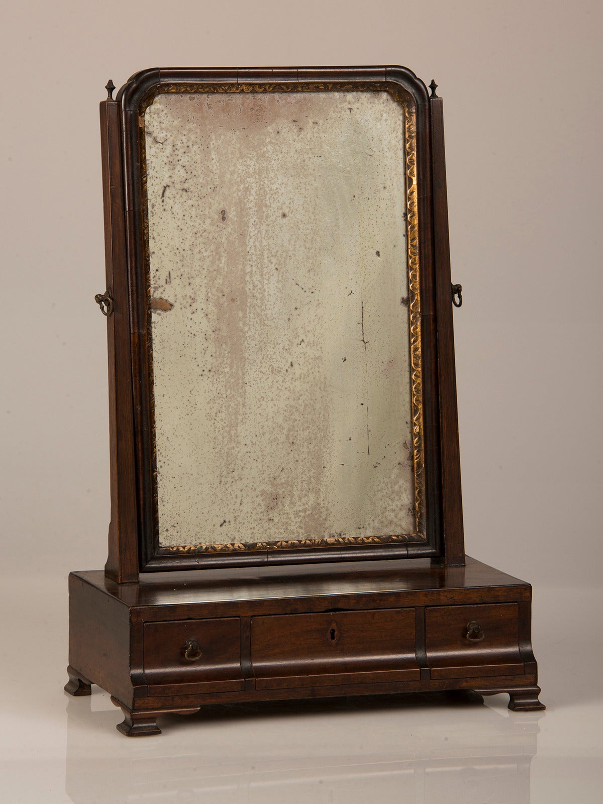 Receive our new selections direct from 1stdibs by email each week. Please click “Follow Dealer” button below and see them first!

An antique English George III period mahogany dressing mirror circa 1790 having a shaped front with three drawers for