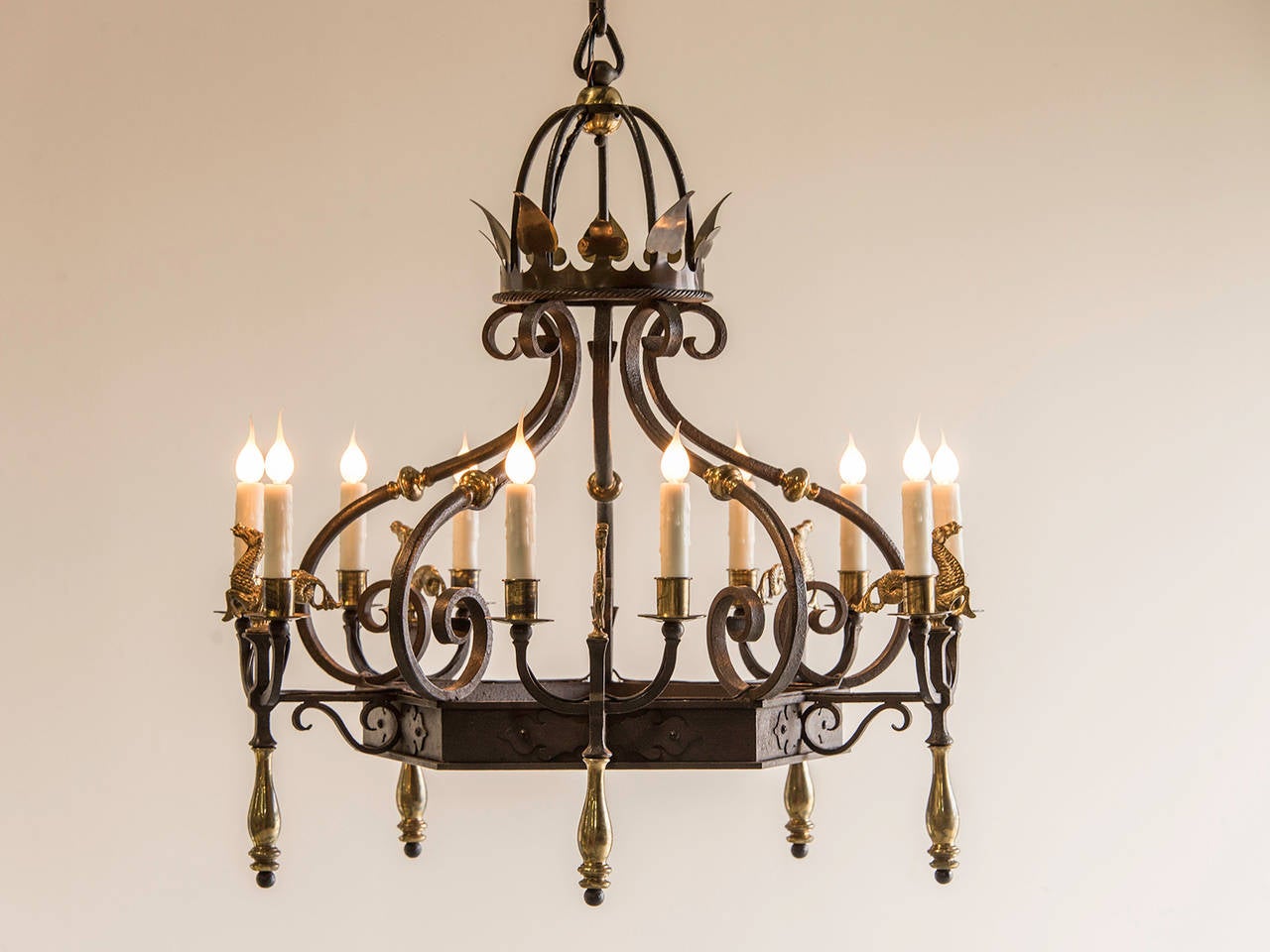 Régence Style Iron and Brass Ten Light Chandelier, France c.1920. The geometric balance and symmetry combined with the fanciful equestrian motifs in this chandelier as well as the strong visual contrast between the dark iron and polished brass make