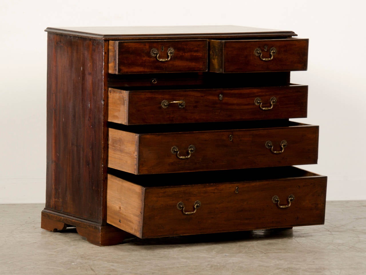 A George III period mahogany chest of drawers from England c.1830 having a dressing/brushing slide standing on bracket feet.